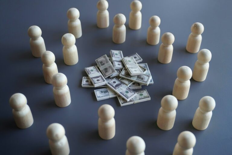 Group of wooden dolls and stack of money.